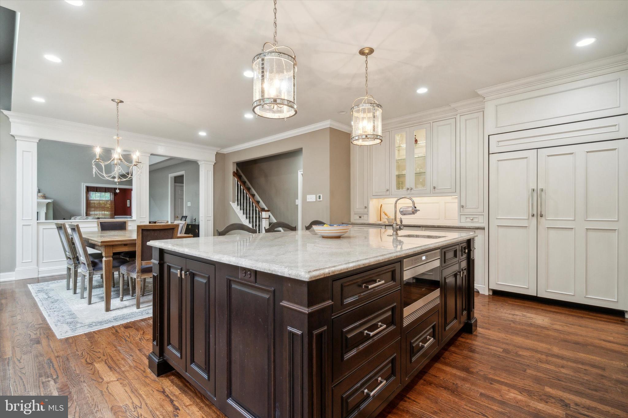 145 Biddulph Road Wayne, PA 19087 - Photo 13 of 38 a kitchen with granite countertop a table chairs stove a refrigerator and a fireplace