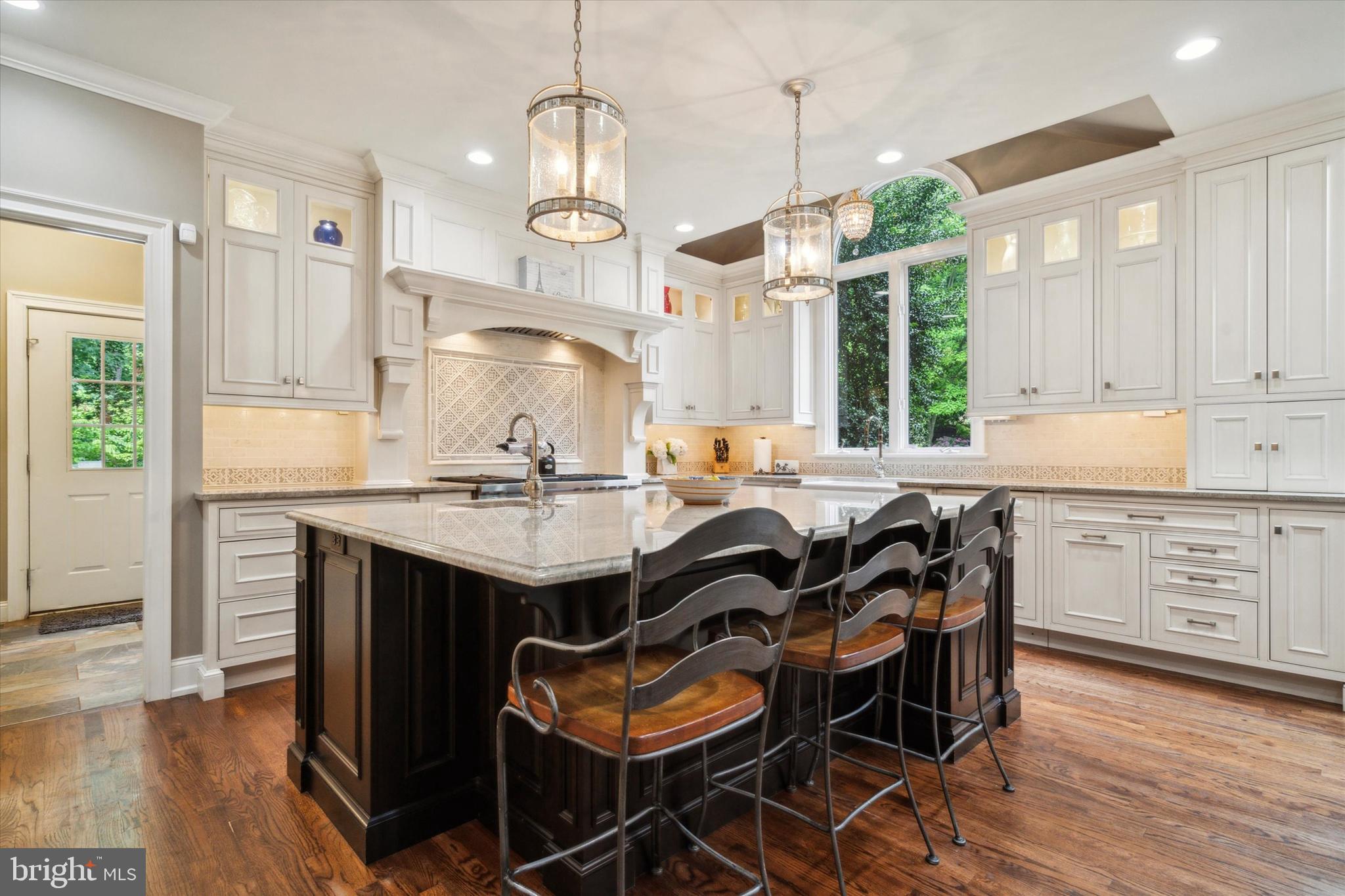 145 Biddulph Road Wayne, PA 19087 - Photo 8 of 38 a kitchen with granite countertop a table chairs a sink dishwasher stove and cabinets with wooden floor