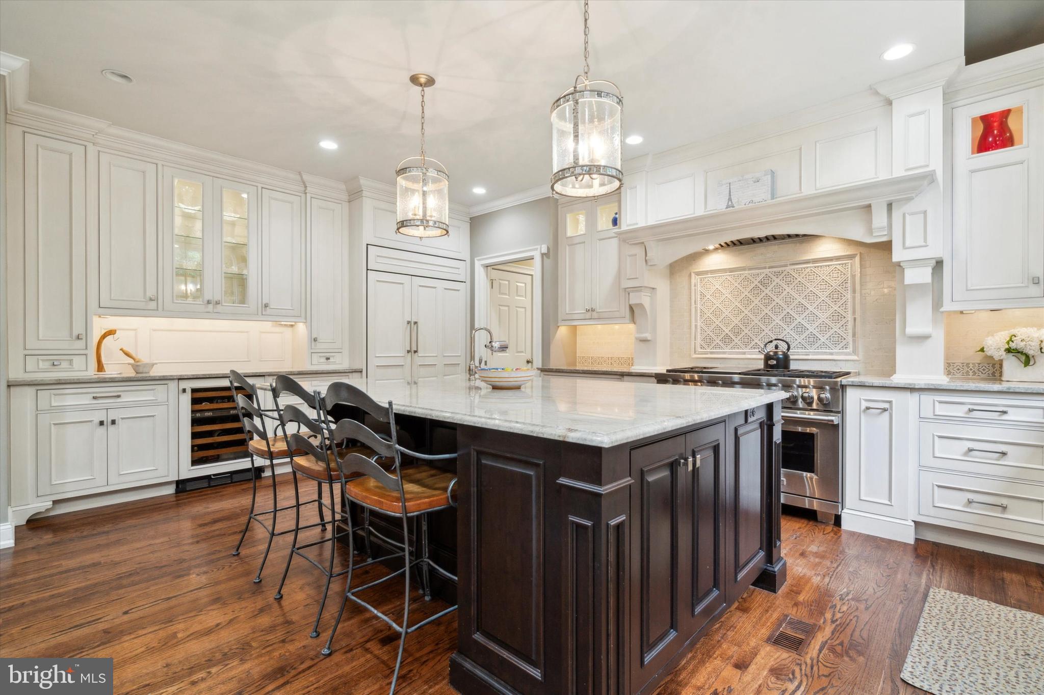 145 Biddulph Road Wayne, PA 19087 - Photo 10 of 38 a open kitchen with stainless steel appliances granite countertop a stove oven a sink dishwasher and white cabinets with wooden floor