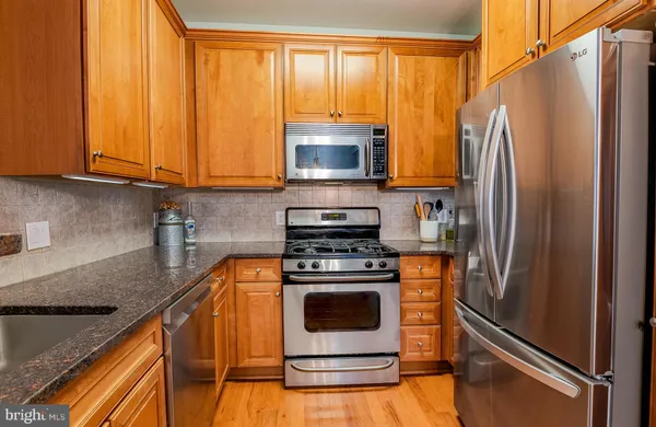 a kitchen with a stove a fridge and a sink
