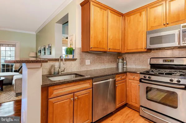 a kitchen with stainless steel appliances granite countertop a stove a sink and a microwave
