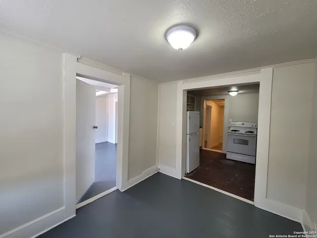 an empty room with a bathroom and a sink