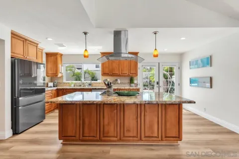 a kitchen with stainless steel appliances granite countertop a sink and a refrigerator