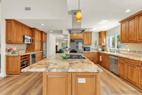 a kitchen with stainless steel appliances kitchen island granite countertop a sink and cabinets