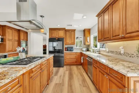 a kitchen with stainless steel appliances granite countertop a sink stove and refrigerator