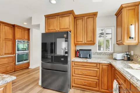 a kitchen with granite countertop wooden cabinets and stainless steel appliances