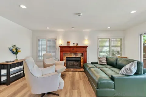a living room with furniture large window and fireplace
