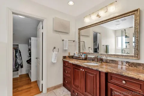 a bathroom with a granite countertop sink and a mirror