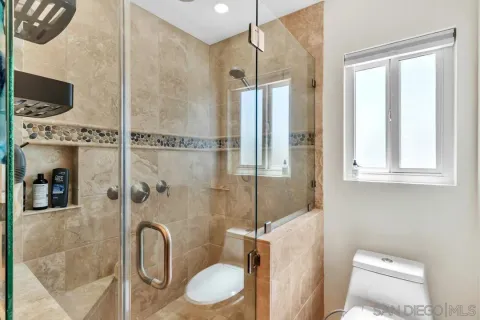 a bathroom with a tub shower sink and mirror