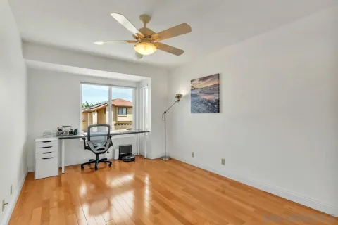 a room with wooden floor and a chandelier fan