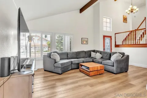 a living room with furniture flat screen tv and a large window
