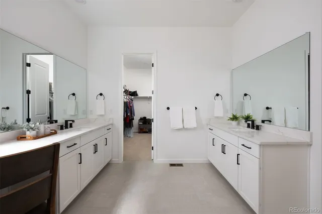 a large white kitchen with a double vanity sink and white cabinets