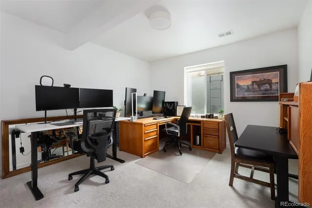 a view of a workspace with furniture and a window