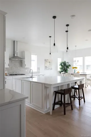 a kitchen with stainless steel appliances granite countertop a white cabinets and chairs