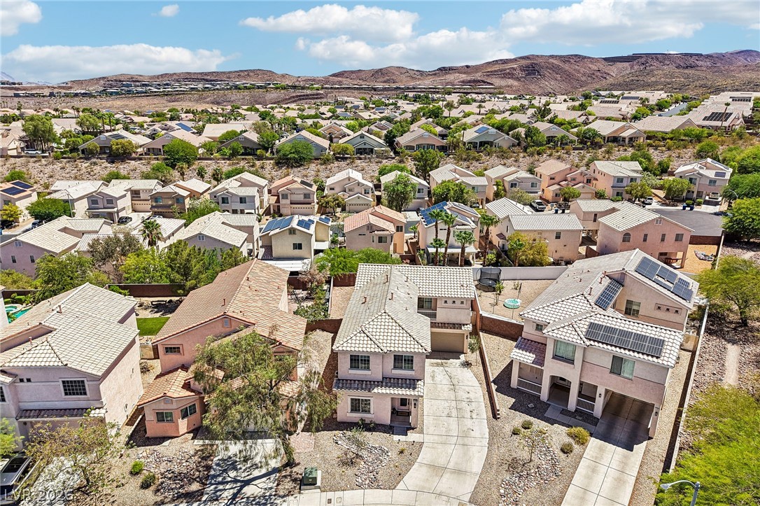 1176 Butternut Ranch Court Henderson, NV 89052 - Photo 48 of 60 An aerial perspective showcases a residential neighborhood nestled against a backdrop of distant mountains.