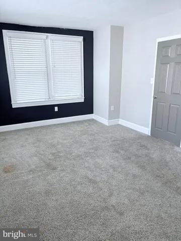 an empty room with wooden floor and cabinet