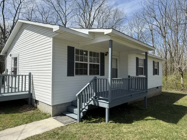 a view of a house with a wooden deck and a yard