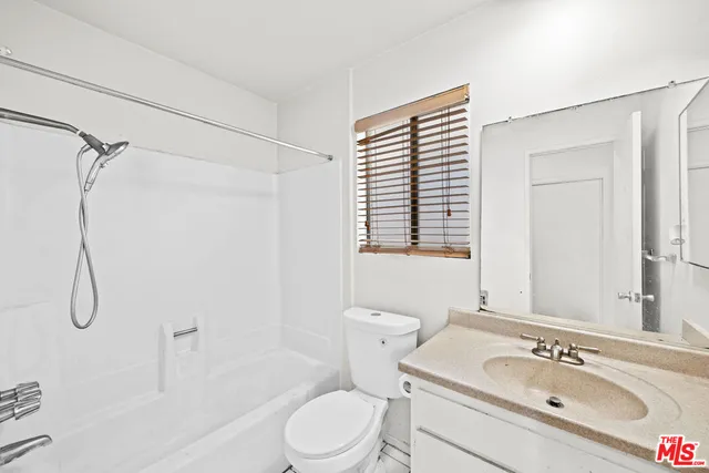 a bathroom with a granite countertop toilet sink and shower