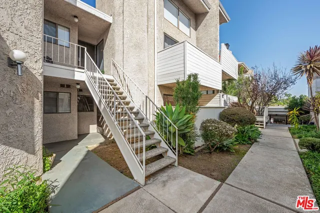 a view of a pathway with house and garden with plants