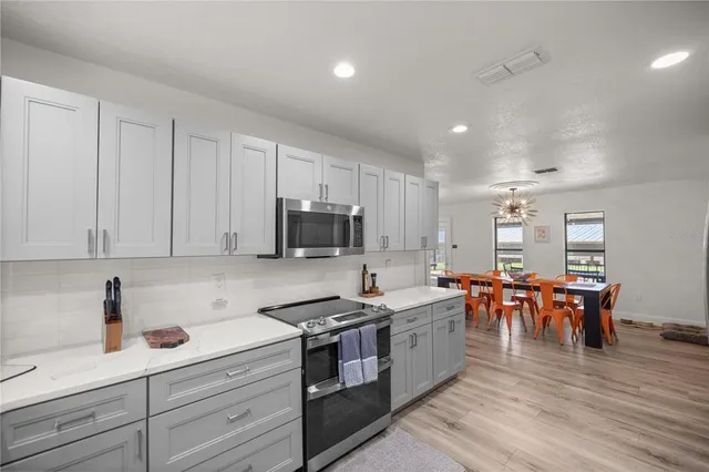 a kitchen with a refrigerator sink and cabinets