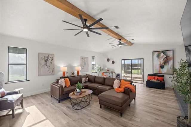 a living room with furniture and a view of kitchen
