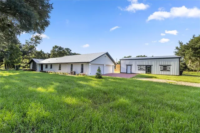 a view of a house with backyard and a hammock