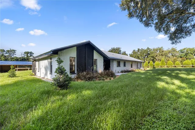 a view of a house with backyard and porch