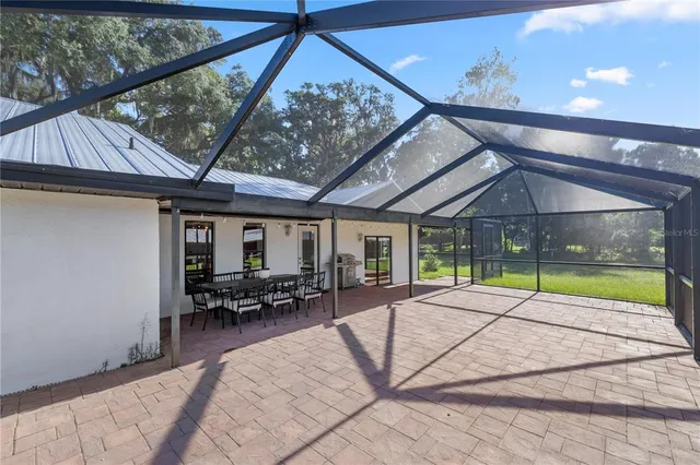 a view of a patio with a table chairs and backyard