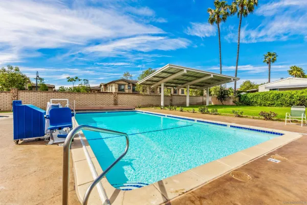 a view of a swimming pool with a patio and a yard