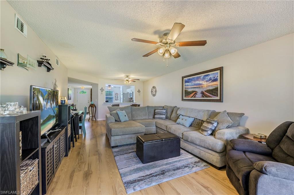 a living room with furniture ceiling fan and a rug