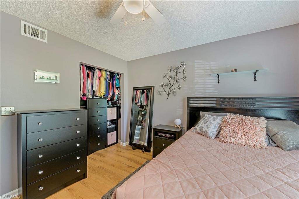 5737 Whitaker Road, Unit C103 Naples, FL 34112 - Photo 12 of 22 a bedroom with a bed and a closet