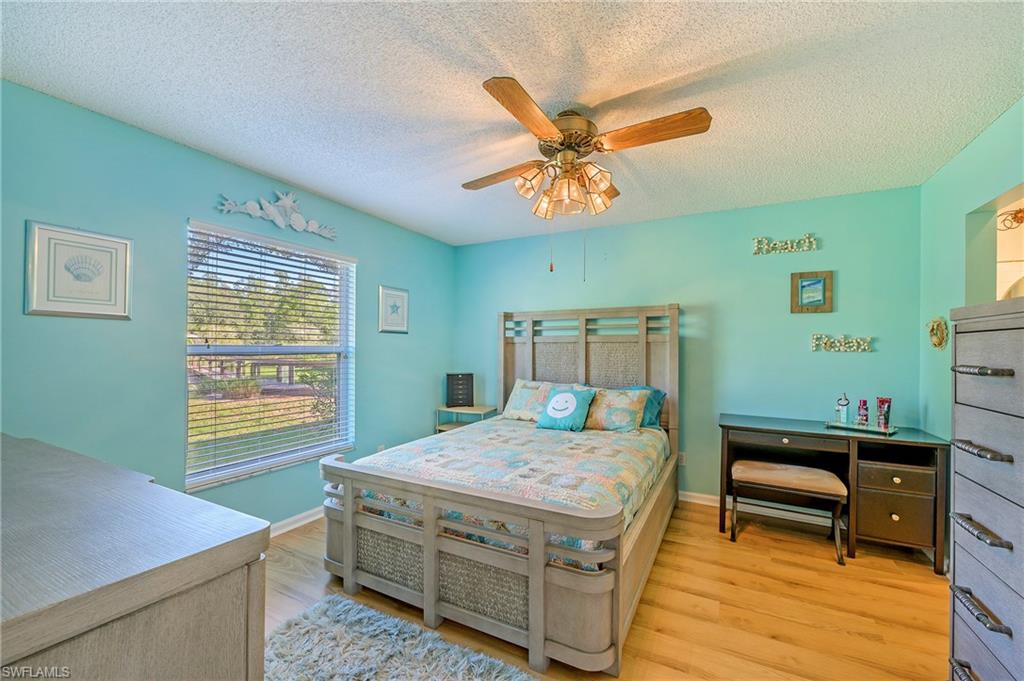 5737 Whitaker Road, Unit C103 Naples, FL 34112 - Photo 14 of 22 a bedroom with a bed and a table in it