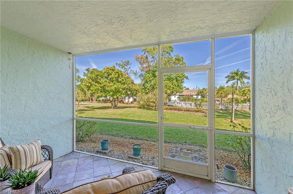 5737 Whitaker Road, Unit C103 Naples, FL 34112 - Photo 19 of 22 a living room with furniture and a floor to ceiling window