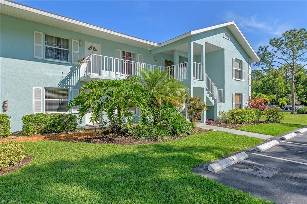 5737 Whitaker Road, Unit C103 Naples, FL 34112 - Photo 2 of 22 a front view of a house with a yard and trees