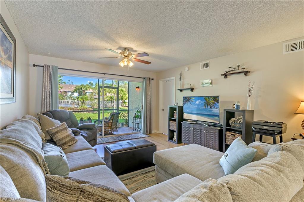 5737 Whitaker Road, Unit C103 Naples, FL 34112 - Photo 4 of 22 a living room with furniture and a flat screen tv