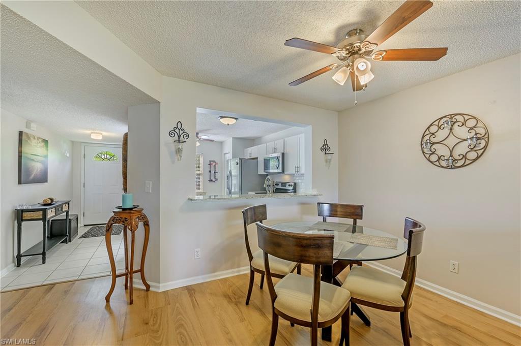 5737 Whitaker Road, Unit C103 Naples, FL 34112 - Photo 6 of 22 a view of a dining room with furniture and wooden floor