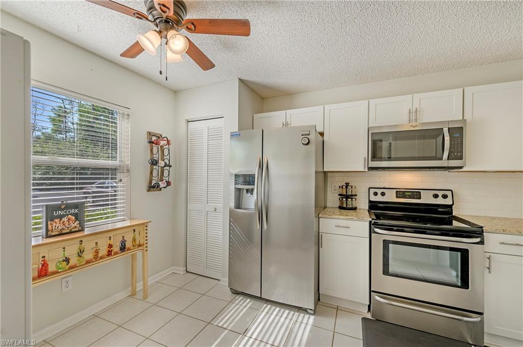5737 Whitaker Road, Unit C103 Naples, FL 34112 - Photo 9 of 22 a kitchen with stainless steel appliances a refrigerator and a stove top oven