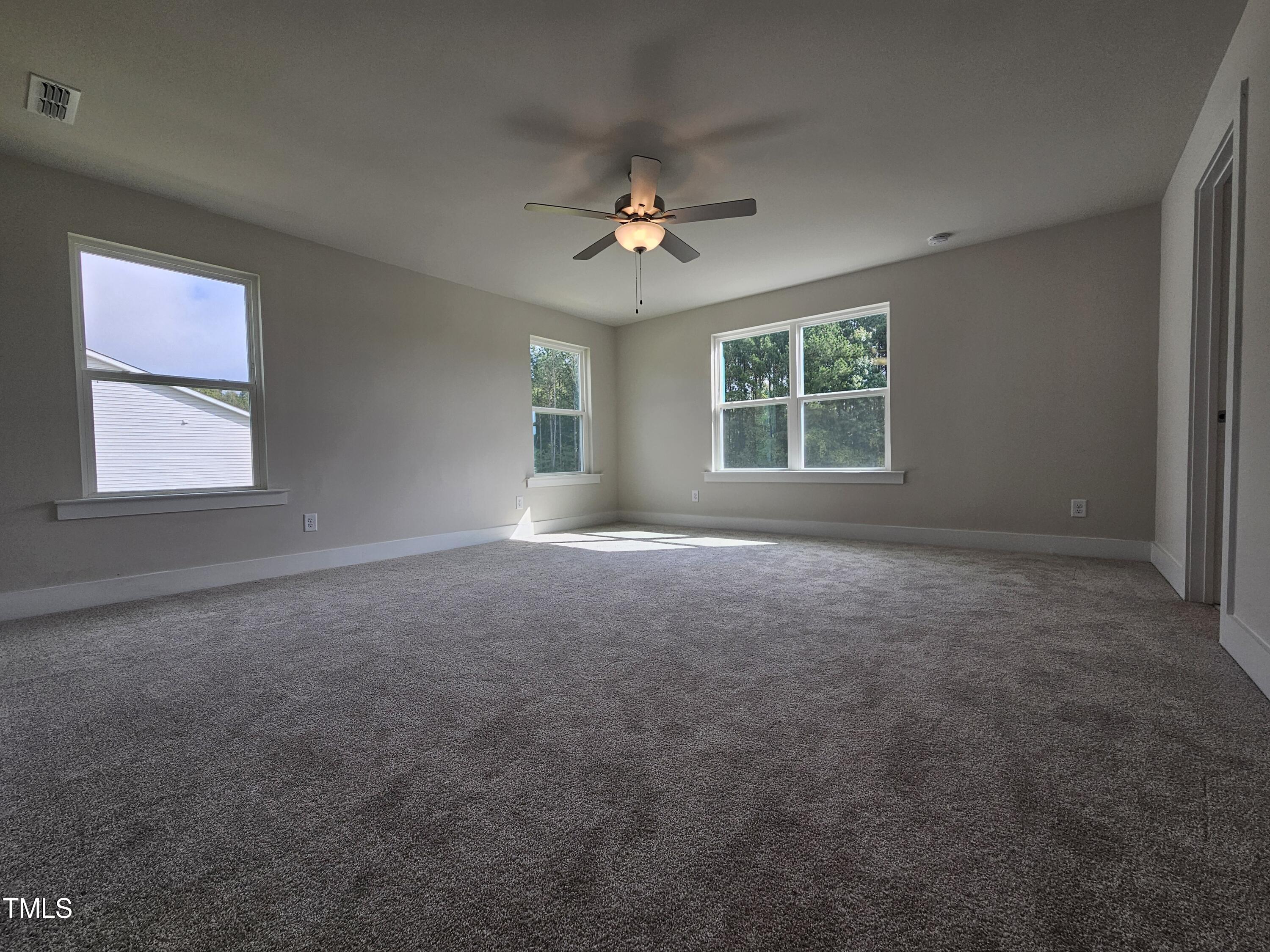 144 Gin Br Road Wendell, NC 27591 - Photo 12 of 18 an empty room with windows and ceiling fan