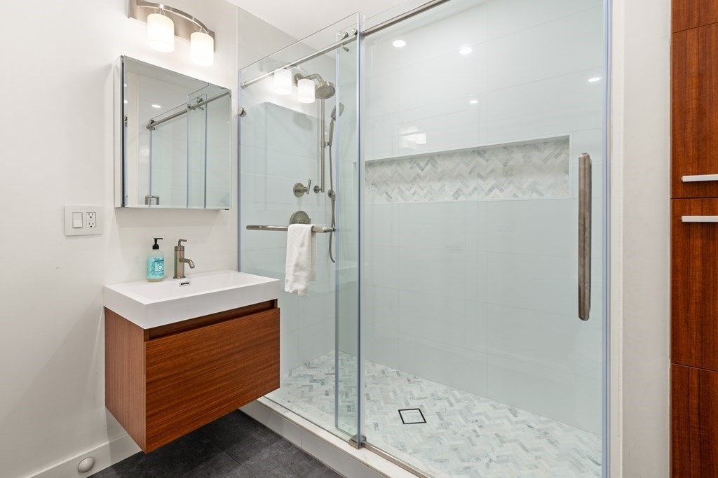 9 Newbrook Circle Newton, MA 02467 - Photo 23 of 28 a bathroom with a shower sink and mirror