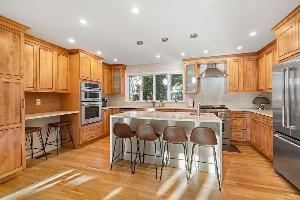 9 Newbrook Circle Newton, MA 02467 - Photo 8 of 28 a kitchen with stainless steel appliances granite countertop dining table chairs refrigerator and sink