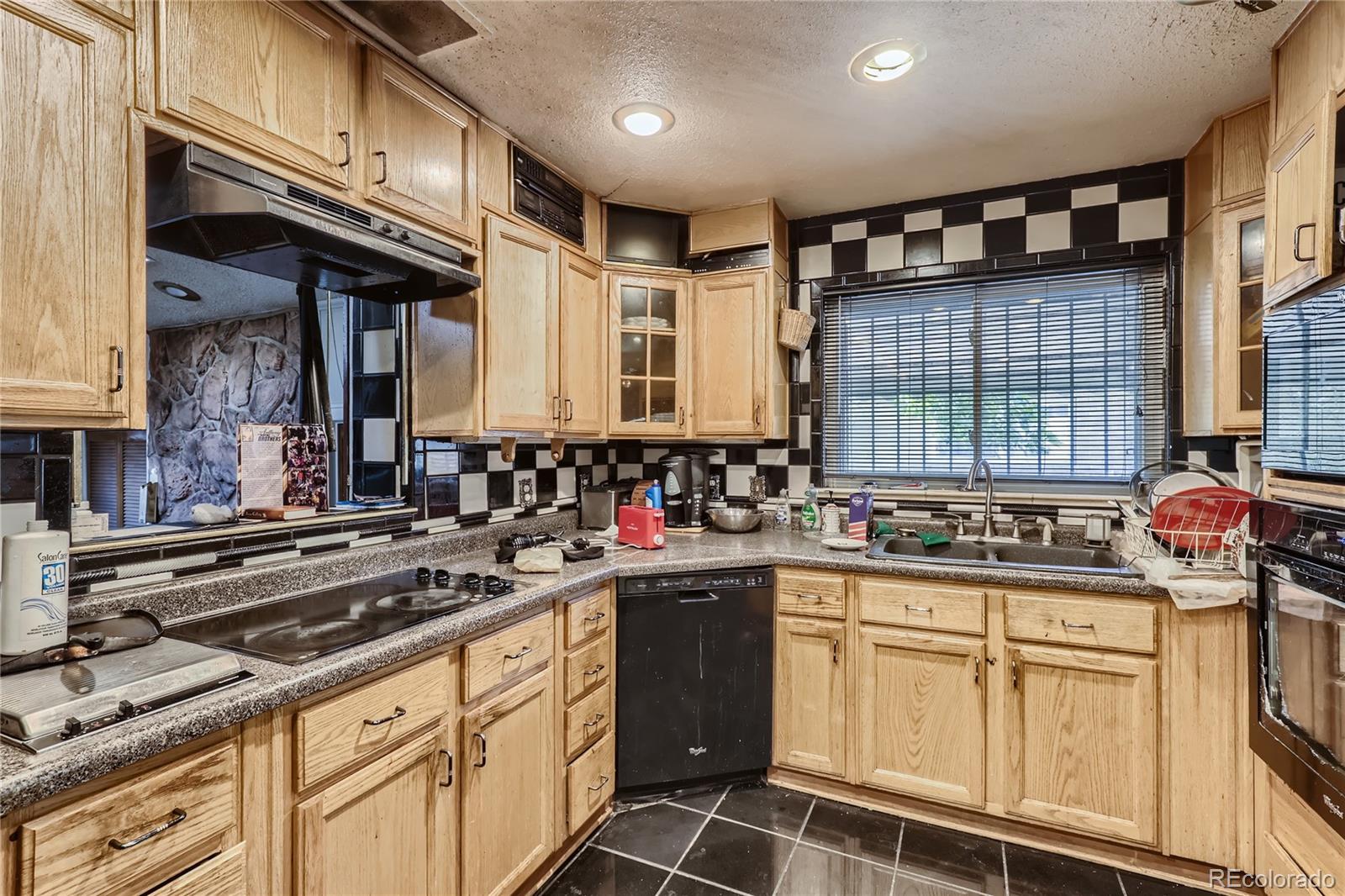 3550 Eudora Street Denver, CO 80207 - Photo 3 of 19 a kitchen with stainless steel appliances granite countertop a sink stove and cabinets