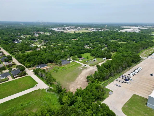 an aerial view of residential houses with outdoor space and trees