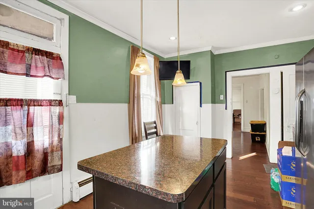 a kitchen with stainless steel appliances granite countertop a table chairs and a refrigerator