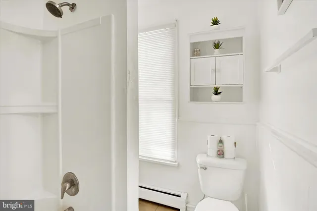 a bathroom with a window a toilet and a sink