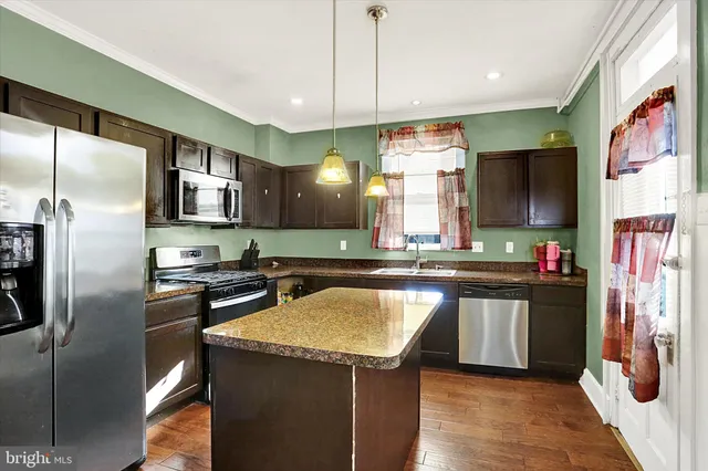 a kitchen with stainless steel appliances granite countertop a refrigerator a sink and a stove