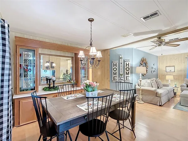 a dining room with furniture a chandelier and wooden floor
