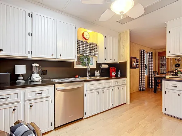 a kitchen with granite countertop white cabinets and white appliances
