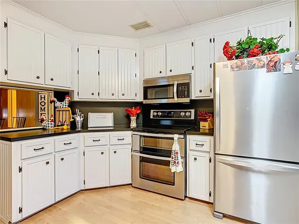 a kitchen with granite countertop white cabinets and white appliances