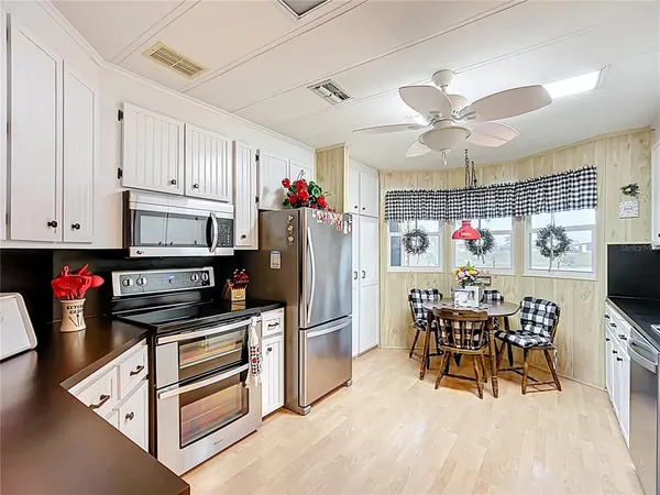 a kitchen with granite countertop a refrigerator and a dining table chair