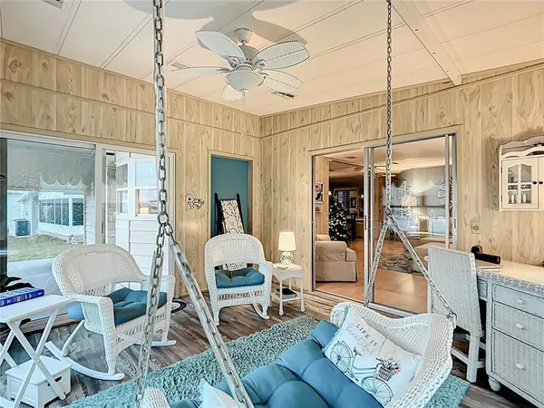 a living room with furniture a chandelier and kitchen view